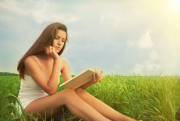 Mädchen liest ein Buch über die Natur — Stockfoto