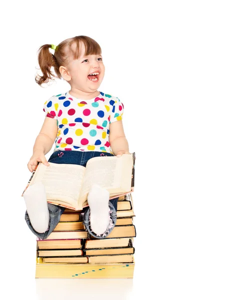分離された本の山に座っている小さな女の子 — ストック写真