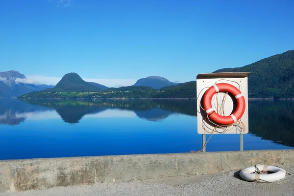 Červené bóje proti modrý pohled fjordu — Stock fotografie