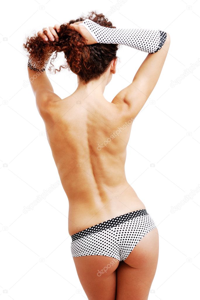 Rear view of topless girl in polka dot shorts and gloves.