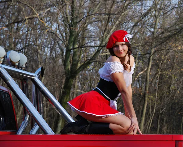 Sexy Mädchen auf dem roten Auto. — Stockfoto