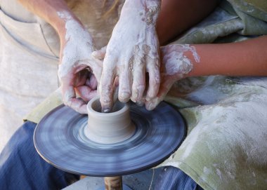 Potters working by the throwing wheel clipart