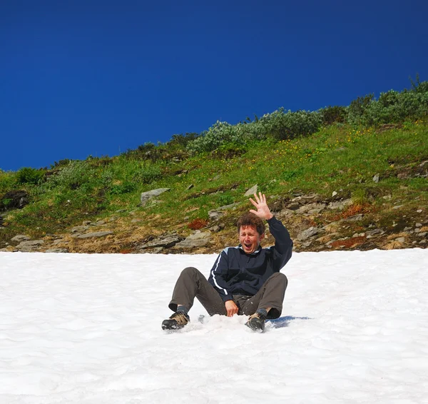 Tourist sliding on the snowfield in summer. — Stock Photo, Image