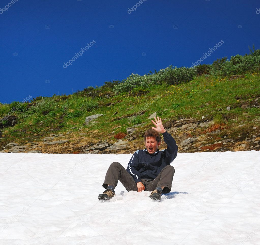 Tourist sliding on the snowfield in summer.