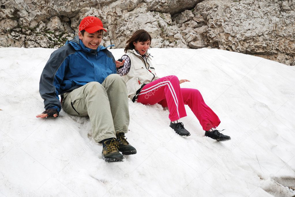 Tourists sliding on snowfield.