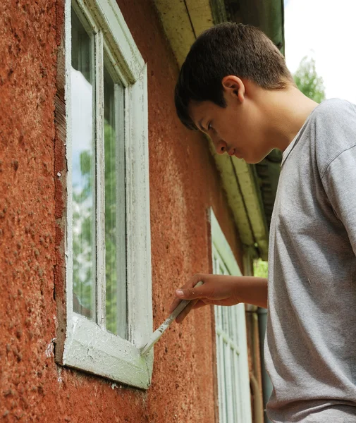 stock image Boy staining window on the outside.