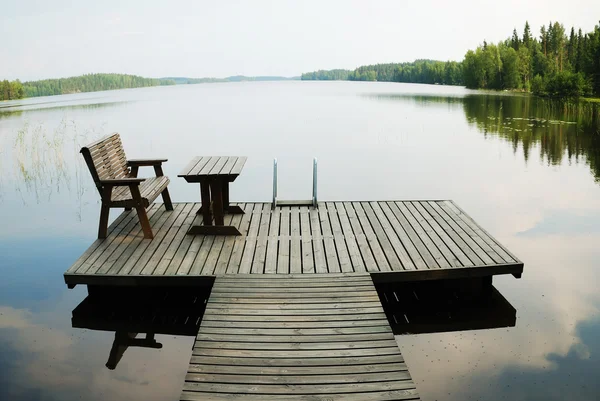 Lago com pequena plataforma de madeira para descanso — Fotografia de Stock
