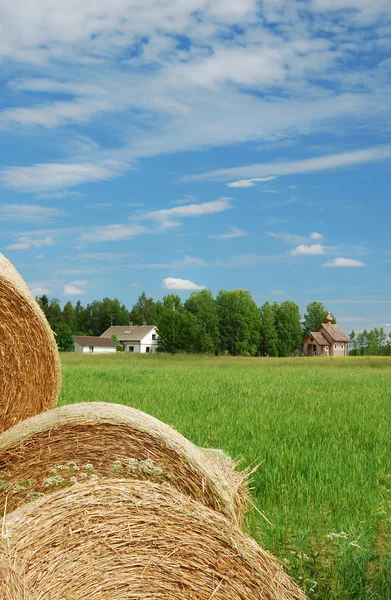Paisagem finlandesa com palha, fazenda e igreja rural — Fotografia de Stock