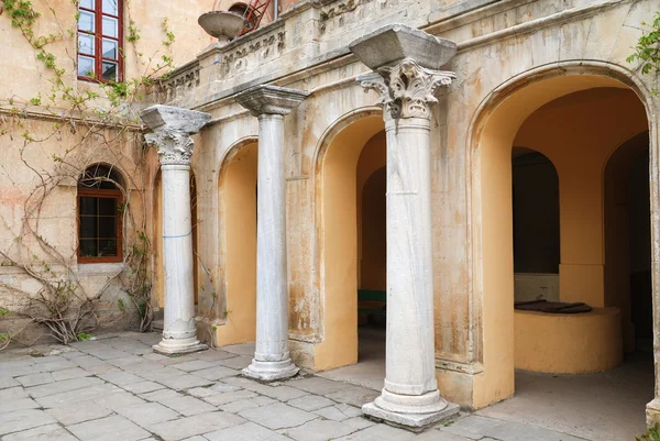 Древние колонны возле старого здания с арками — стоковое фото