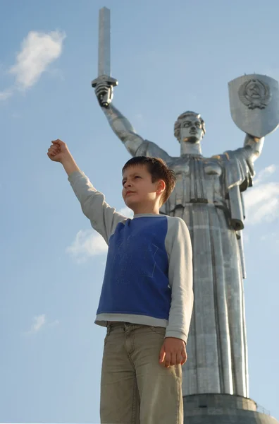 Boy standing near monument of Motherland, bottom view. — Stock Photo, Image