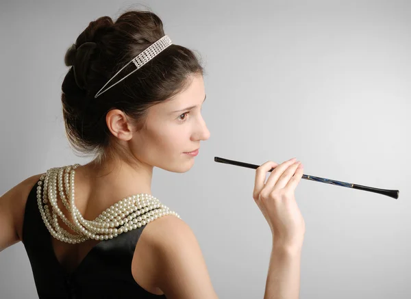 Elegant girl with cigar-holder, side view — Stock Photo, Image