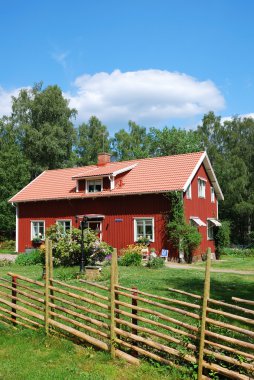 Red Swedish house in the middle of nature clipart