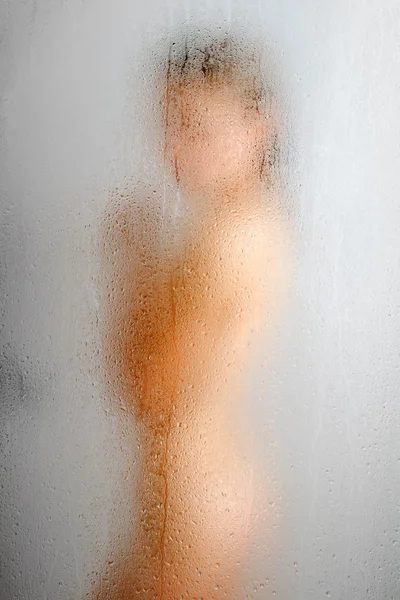 Weeping glass of shower and blurred female body. — Stock Photo, Image