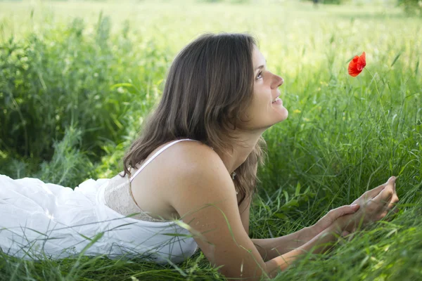 Jovem feliz bonita com uma papoula em um prado — Fotografia de Stock