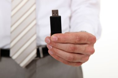 Businessman holding a USB stick clipart