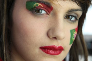 Attractive Portuguese woman with national flag painted on face clipart