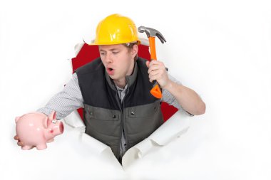 Tradesman about to break open his piggy bank clipart