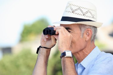 Old man looking through binoculars clipart