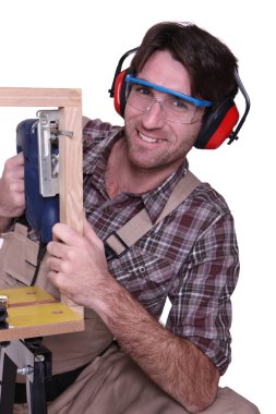 Carpenter sawing wooden frame clipart