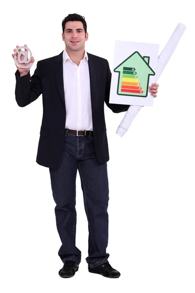 Man holding a at sign and a diagram. — Stock Photo, Image