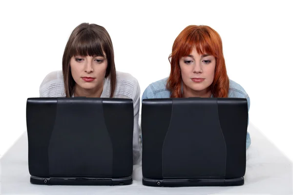 Дві молоді жінки пліч-о-пліч з ноутбуками — стокове фото