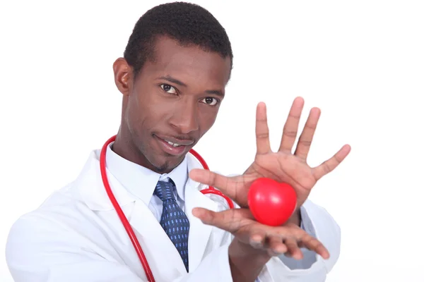 Мужчина-врач держит игрушку в форме сердца — стоковое фото