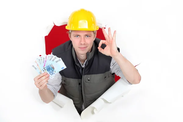 Craftsman holding money and making an okay sign — Stock Photo, Image
