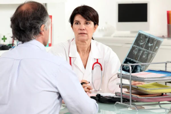 Doctor presenting x-ray results to patient — Stock Photo, Image