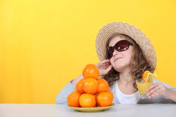 Liten flicka med färskpressad apelsinjuice — Stockfoto