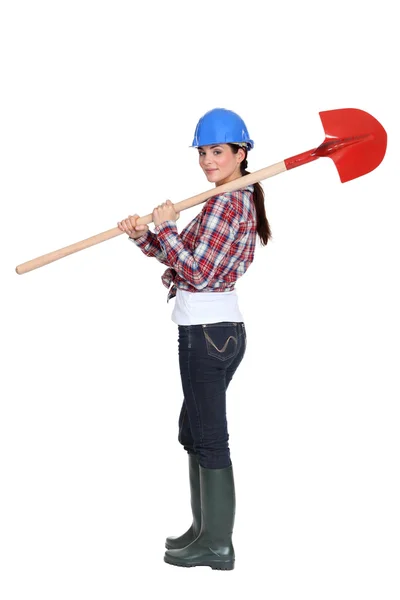 Female manual worker carrying shovel — Stock Photo, Image