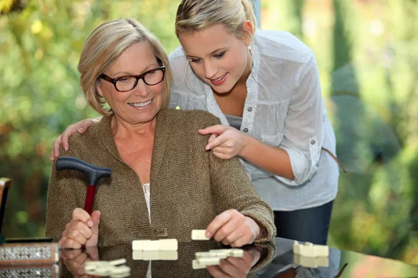 Бабушка и внучка играют в домино — стоковое фото
