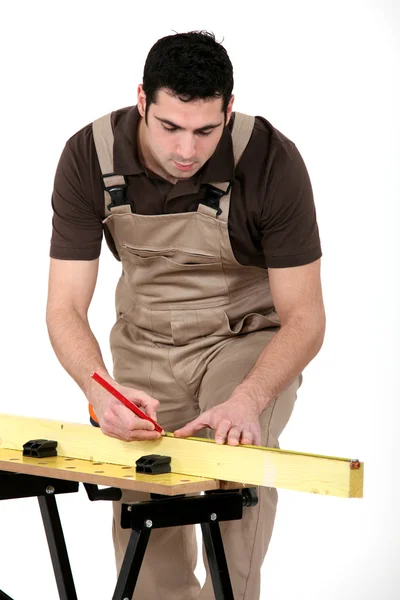 男子测量一块木板 — 图库照片
