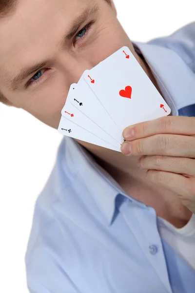 Junger Mann hält während eines Spiels seine Karten hoch — Stockfoto