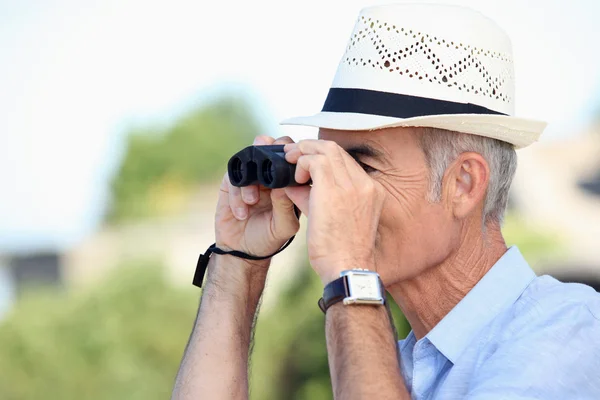 Oude man op zoek door middel van verrekijkers — Stockfoto