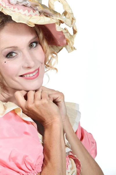Mulher em um vestido de rosa e creme teatral e capota — Fotografia de Stock