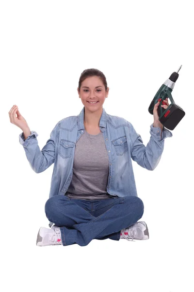 Mladá žena držící elektrický šroubovák — Stock fotografie