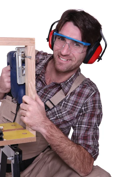 Carpenter sawing wooden frame — Stock Photo, Image