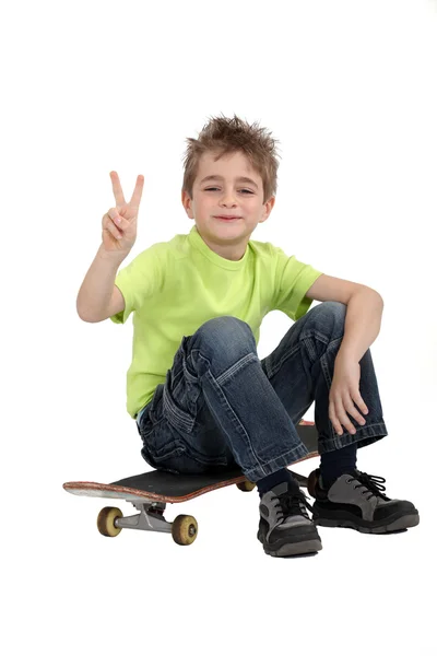 Jongen zit op skateboard — Stockfoto