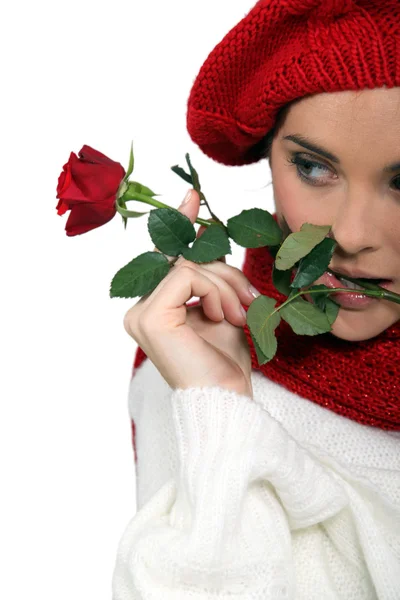 Жінка одягнена на зиму тримає троянду — стокове фото