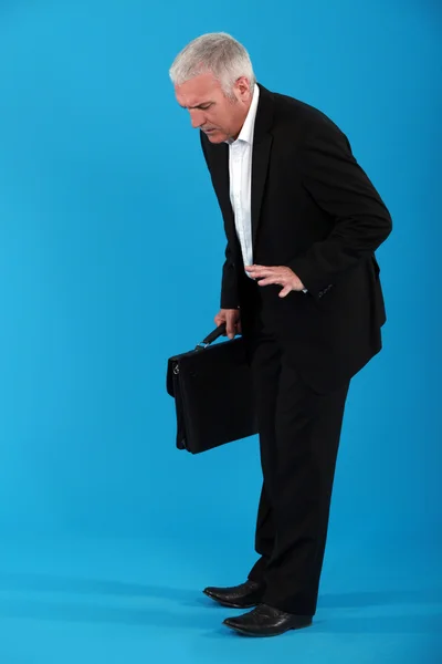 Hombre de negocios mirando un objeto en el suelo —  Fotos de Stock