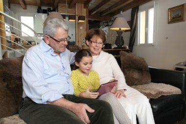 Old couple sat with their granddaughter clipart