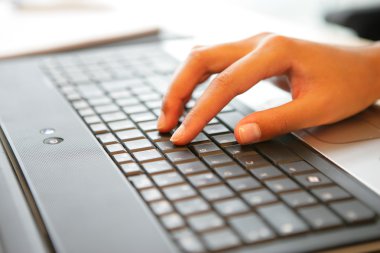 Hand placed on laptop keyboard clipart