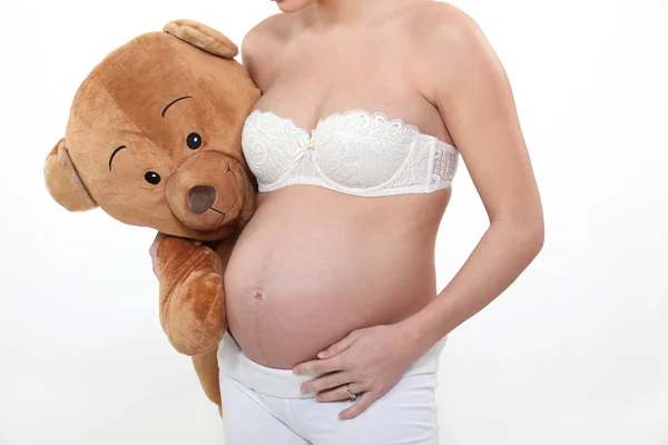 Беременная женщина с плюшевым мишкой — стоковое фото