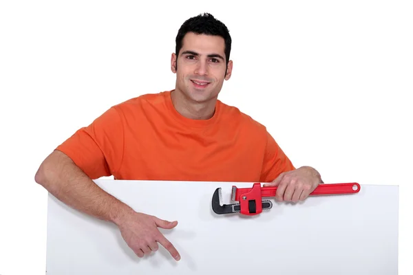 Man stood with wrench and poster — Stock Photo, Image