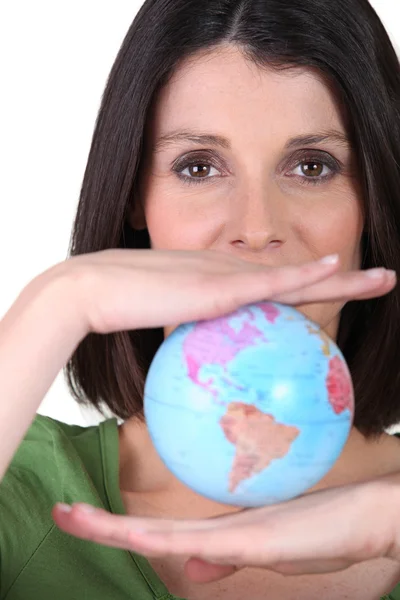Женщина держит миниатюрный глобус — стоковое фото