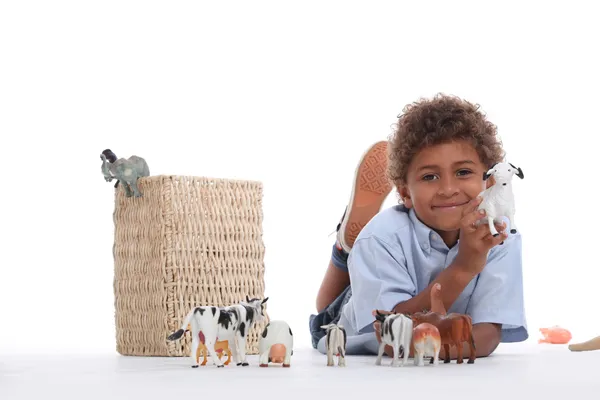 Malý chlapec hraje s plastová hračka zvířata — Stock fotografie