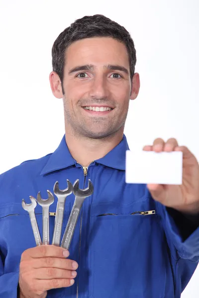 A 35 years old mechanician is showing a business card — Stock Photo, Image