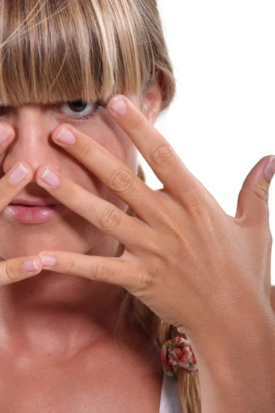 Giovane donna dai capelli biondi si nasconde il viso dietro le mani — Foto Stock