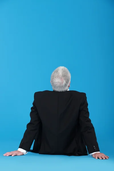 Hombre mayor sentado con la espalda vuelta — Foto de Stock