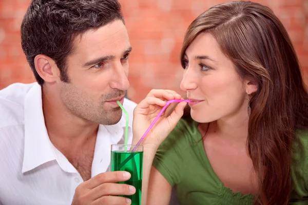 Couple sharing drink — Stock Photo, Image